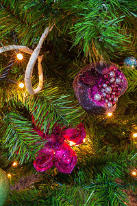 紧贴一棵圣诞树在紫色主题下装饰有突出的紫色石榴和挂花装饰内部的灯冬天图片