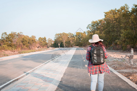 带背在沥青路农村地区行走的女旅妇游客景观成人图片