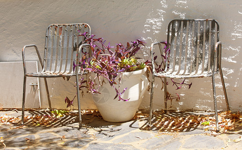 座位桌子颜色两个老旧的金属古董花园椅和瓶图片