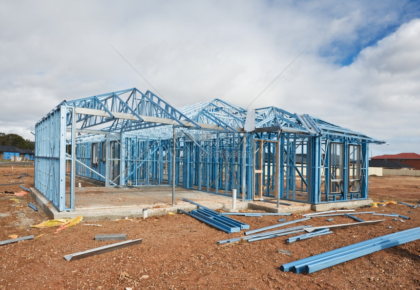 屋顶钢结构框架正在建造中的新住宅使用钢架对付阴云的天空图片