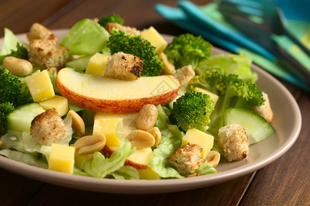 吃水平的新鲜素食沙拉配有苹果生菜花西椰黄瓜奶酪和自制的烤面包以自然光拍攝选择焦点关注苹果切片前面图片