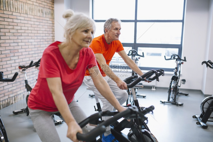 健身房骑动感单车运动的老年夫妇图片