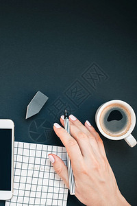 躺着女办公桌工作空间的顶楼有智能手机和咖啡杯在博客社交媒体黑背景模板上有影印版妇女工作室静止的仙人掌图片