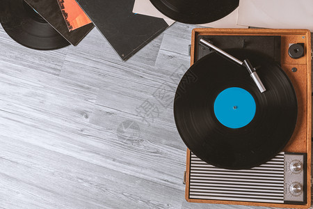光盘复古的在灰色木制桌顶视图和复制空间上有黑乙烯胶唱片的旧式喇叭记录图片