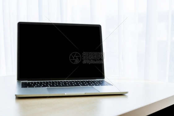 在办公室背景工作业务概念中用白色空屏幕在窗户内木制桌子部的门面上装笔记本电脑沟通家键盘图片
