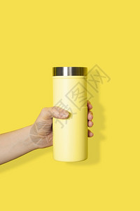 户外手握黄色旅行杯隔离在白色背景上饮料或者背景图片