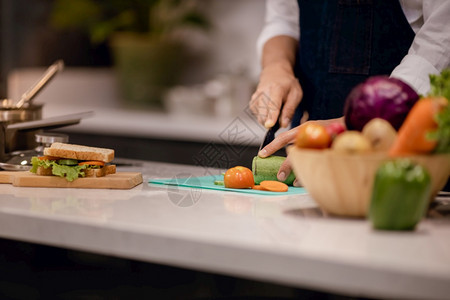 健康男人一顿饭厨师制作桑威奇三明治用于厨房的早餐在家用手切菜机上按台裁剪图象图片