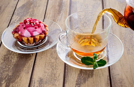 茶碗玻璃一杯加糖和薄荷的新鲜浓茶杯一含薄荷和茶壶的杯在木制背景上液体图片