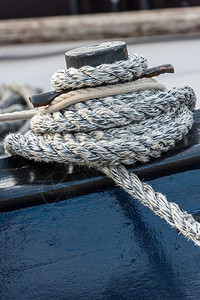螺旋绑在木制码头的一扇锁链上用绳子系住索打结的圆形图片