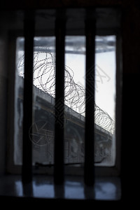 透过监狱窗户的阴暗和景象窗上栅栏与墙只有铁丝网圈的眼线象征着囚犯没有自由这代表着倒钩拉根非洲图片