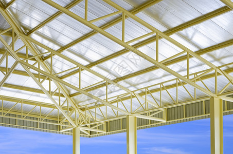 蓝色天空背景建筑工地内黄金属建筑屋顶结构加热隔层的低角度和视侧面图蓝天背景建筑工地结构体几何的白色图片