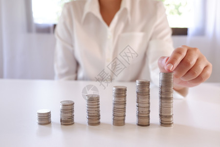商业界人士将硬币放置在增加的硬币堆叠上保持商人贷款图片