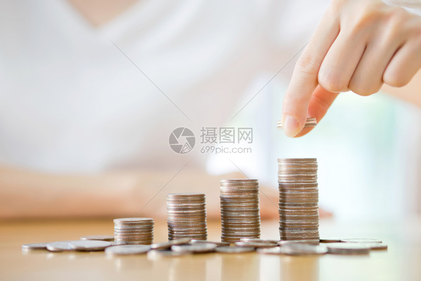 节省投资利润女人把硬币放在一堆上图片