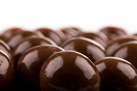 品尝对待紧缩多种巧克力球糖果成分在白色背景上隔开与白色背景隔绝图片