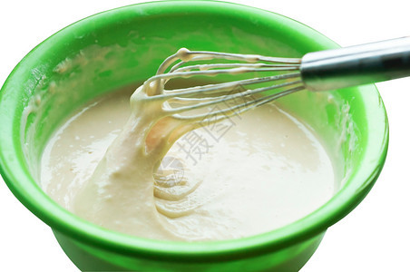 一种糕点蛋碗和面团搅拌将混合在绿色盘中将面团混合在绿色盘中图片