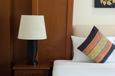 活的卧室内有枕头和床边的阅读灯长椅家具图片