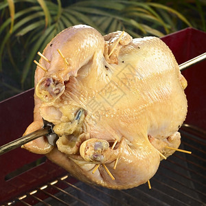 一种准备整只鸡在烧烤木炭上吐口水时被烤鸡选择焦点专注鸡腿重图片