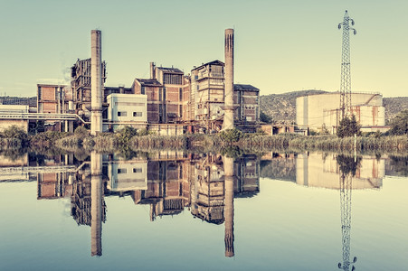砖过时的在Photo河中以古老风格反映的旧工厂云图片