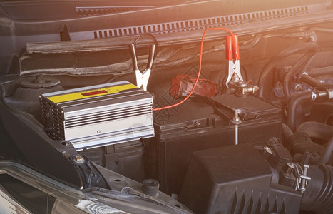 耀斑聪明的车库用便携式电池充器和汽车发动机上的跨接电缆为汽车池充图片