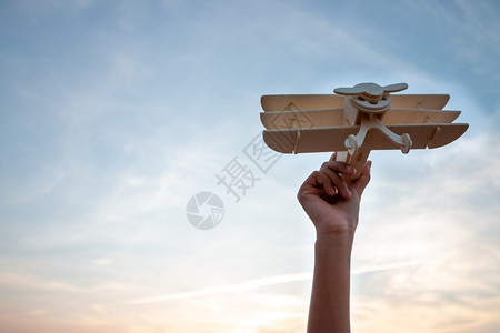 快乐的孩子玩具木机在日落的天空背景下游戏水平的微笑可爱图片