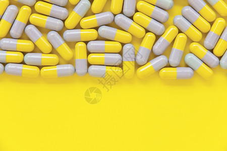 黄色背景下的胶囊药物图片