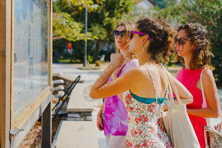 天户外3名女旅游客在暑假信息介绍日观看希腊旅游目的地信息面板上图点以了解休假日信息方向7月1日至630人们图片