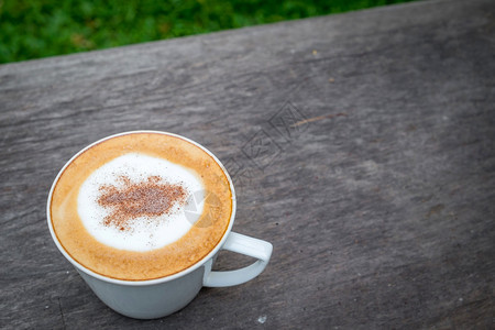 茶卡布奇诺咖啡在花园的木制桌上用白杯装着咖啡饮料草图片