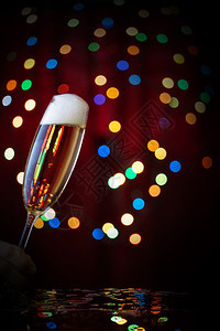 泡沫状的气节日背景下带有冒泡香槟的倾斜玻璃庆祝活动的概念节日背景下带有冒泡香槟的倾斜玻璃流动图片