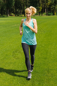 肖像慢跑者一位活跃的美丽天主教女在公园户外奔跑运动服图片
