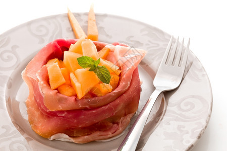 以白色孤立背景的西红柿和甜瓜拍摄了一幅美味切片培根的照萨拉米零食图片