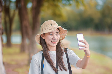 带智能电话旅行的美女自拍相片机户外女士图片