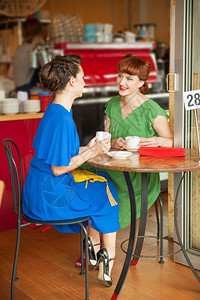 衣服桌子在后咖啡馆两个漂亮的女孩在回古风格白色的图片