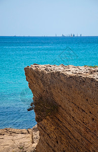 美丽的海滩晴天在西班牙马洛卡Mallorca的阳光明媚夏日海景与岩石和Regatta图片