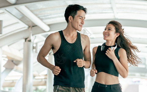 竞技城市的锻炼亚洲健康和运动夫妇互相微笑跑步和慢户外运动生活方式概念图片