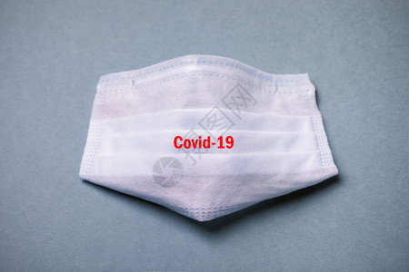 面具关心Covid19保护概念从属在蓝色背景上戴医疗保护面罩上刻有Covid19卫生保健图片
