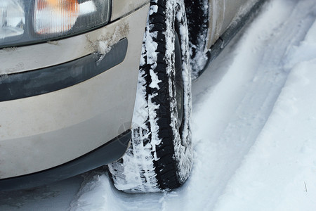 滑危险的冬季汽车轮胎在被雪覆盖的道路上特写镜头冬季汽车轮胎在被雪覆盖的道路上特写镜头阳光图片