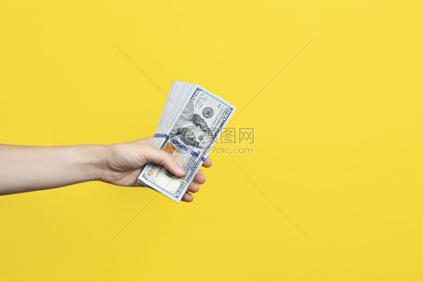 手拿着一大叠钞票在黄色背景上隔离财富或贷款概念横幅与复制空间手拿着一大叠钞票在黄色背景上隔离财富或贷款概念横幅与复制空间百给予市图片