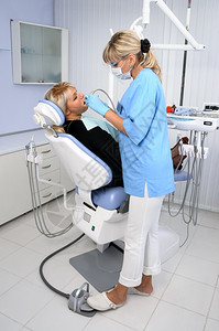 给病人检查牙齿做手术的牙医图片