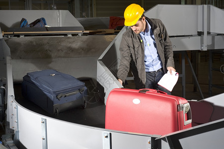 手控制耳朵一名维修工程师检查机场的行李处理传送带一名维修工程师视察机场图片