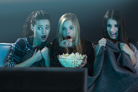 年轻女孩们看恐怖电影吃爆米花图片