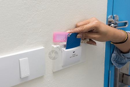 电子的代码酒店亚洲女手持门出入控制卡扫描钥匙以锁和门的亚洲女手持卡图片