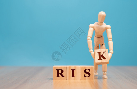 保险Wooden木偶傀儡站立并持有一个带风险词的木板立方体关于商业危机和风险投资控制的评估和分析概念危险战略图片
