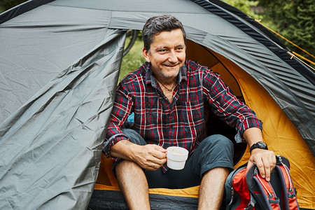 暑假期间在露营帐篷中放松的男子图片