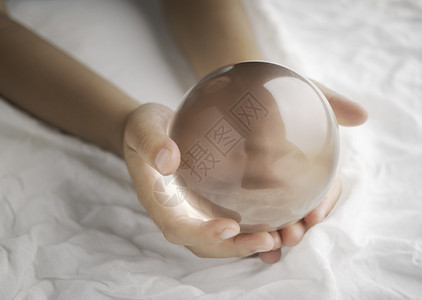 抽象的手握着晶玻璃球在白布背景上透明头脑预兆图片