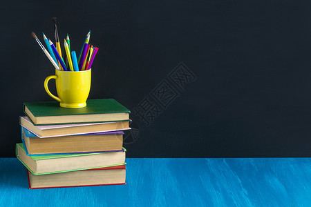 在家工作架子概念教育工作场所学生书籍文具在蓝色桌子上的背景黑色板布局复制空间工作场所学生书籍文具在蓝色桌子上的背景bla木板图片