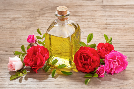 滴管放松木制桌上玻璃瓶中玫瑰基本油香水图片