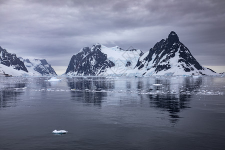南极半岛的美丽风景岩石冰雪和山以及漂浮的冰层全景方面偏蓝图片