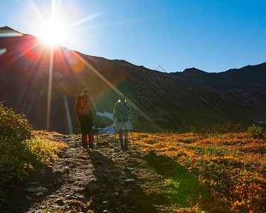 自然极端远足太阳下山上的两个徒步者图片