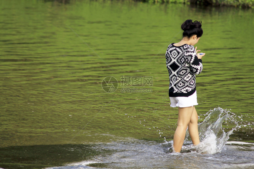模型亚洲人女孩在水里走着电话旅行