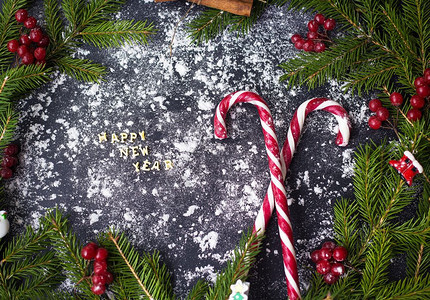 季节卡片圣诞或新年装饰背景为树枝黑色背景上的糖果圣诞节或新年装饰背景为树枝黑色背景上的糖果白色图片